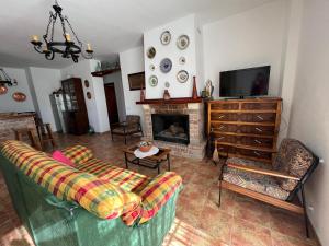 sala de estar con sofá y chimenea en Casa La Era de Abdalajis-Caminito del Rey, en Valle de Abdalajís