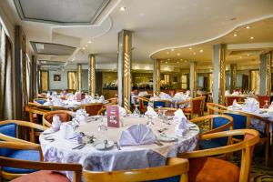 a restaurant with tables and chairs with white tablecloths at Nile Treasure Cruise - 4 or 7 Nights From Luxor each Saturday and 3 or 7 Nights From Aswan each Wednesday in Luxor