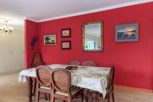una sala da pranzo rossa con tavolo e specchio di Cherry on Top a Morgan's Bay