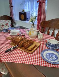 een tafel met brood en een snijplank met toast bij Tosses Cottage - Secluded cottage with hot tub in Newry