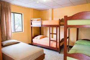 a room with two bunk beds and a window at Hostel Nucapacha in Guayaquil