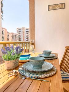 una mesa de madera con tres cuencos y platos en ella en Apartamento La Manga, Urbanizacion Oasis, en La Manga del Mar Menor