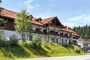 a large building on a hill with a tree at Apartment, 2 bedrooms, kitchen+2 bathrooms in Mitterfirmiansreut