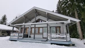 a small house in the snow with snow at Villa Aurora, Himos in Jämsä