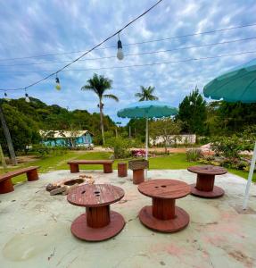 a group of picnic tables and umbrellas in a park at VILA ACONCHEGO AZUL- casa 1 in Aracê