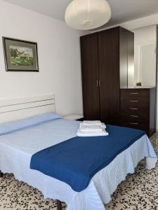- une chambre avec un lit doté de draps bleus et une armoire dans l'établissement La Cruz Negra de Veruela, à Vera de Moncayo