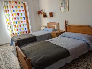 a bedroom with two beds and a colorful curtain at La Cruz Negra de Veruela in Vera de Moncayo
