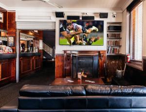 a living room with a couch and a tv at Family Hotel in Bathurst