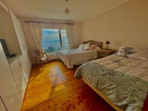 a bedroom with two beds and a window at Hostal Casa Grande in Puerto Montt