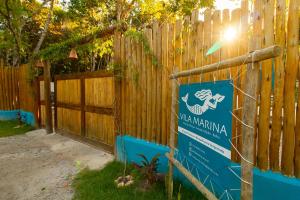a sign in front of a wooden fence at Vila Marina in Arraial d'Ajuda