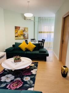 uma sala de estar com um sofá verde e uma mesa em New Apartment in Center of Tirana em Tirana
