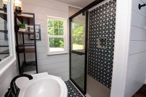 une salle de bain avec un lavabo et une douche en verre dans l'établissement Little Blue Cottage: a wooded getaway near beaches and towns, à Benton Harbor 11 autres photos