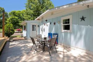 un patio avec une table et des chaises devant un bâtiment dans l'établissement Little Blue Cottage: a wooded getaway near beaches and towns, à Benton Harbor