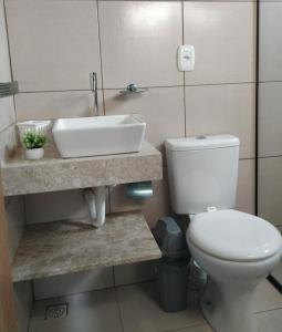 a bathroom with a white toilet and a sink at Chalé Pôr do Sol in Bananeiras
