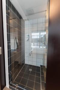 La salle de bains est pourvue d'une douche avec une porte en verre. dans l'établissement Apartamento moderno 1 habitación y 1 baño, área Cayalá Embajada USA CASH ONLY, à Guatemala