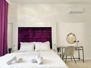 Schlafzimmer mit einem großen Bett mit einem lila Kopfteil in der Unterkunft Bed & Breakfast Donji Grad in Zagreb