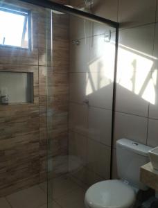 a bathroom with a toilet and a glass shower at Chalé Pôr do Sol in Bananeiras