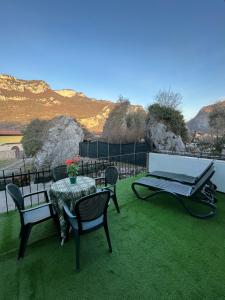 a patio with a table and chairs on the grass at Appartamenti Le Calle in Nago-Torbole