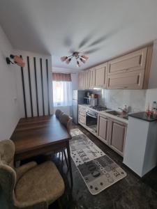 eine Küche mit einem Holztisch und Stühlen in der Unterkunft Apartament Eve in Câmpulung Moldovenesc