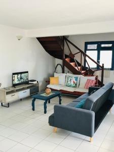 a living room with a couch and a table at Villa Sous le Manguier-Anse Bertrand 5min plage in Anse-Bertrand