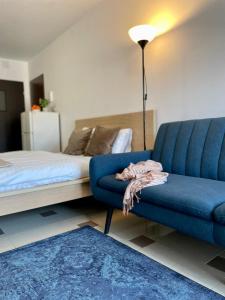 a living room with a blue couch and a bed at Bubble Apartments in Krakow