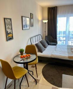 een woonkamer met een bed en een tafel en stoelen bij Bubble Apartments in Krakau