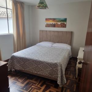 a bedroom with a bed and a window at Apart Hotel Don Ernesto in Lima