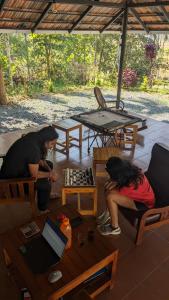 two women playing chess under a tent with a table at Crossroads Hostel 1957 in Wayanad
