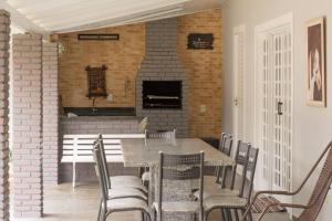 a dining room with a table and chairs and a fireplace at Chácara Recanto da Paz in Pinhalzinho