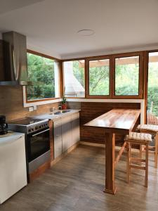 a kitchen with a wooden table and some windows at Casa Golf in Sierra de los Padres