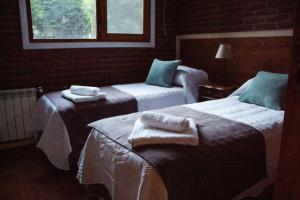 a hotel room with two beds with towels on them at Casa Golf in Sierra de los Padres +72 photos