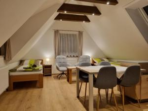 a attic living room with a table and chairs at Apartmán U Bašty in Vimperk