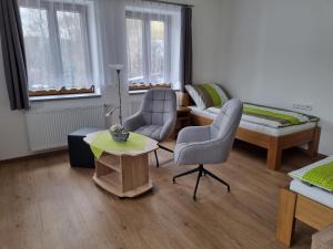 溫佩爾克的住宿－Apartmán U Bašty，客厅配有两把椅子和一张桌子