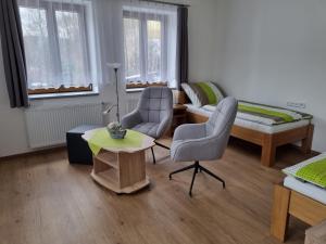 sala de estar con 2 sillas y mesa en Apartmán U Bašty, en Vimperk