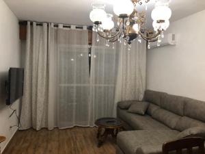 salon z kanapą i żyrandolem w obiekcie Carla24, AVENIDA PRINCIPAL w mieście Águilas