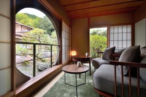 a living room with a couch and a large window at Oni no Sumika in Izu