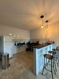 una cucina con bancone, alcune sedie e frigorifero di Casas do Serrano a Lençóis