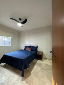 1 dormitorio con 1 cama azul y ventilador de techo en Casas do Serrano en Lençóis
