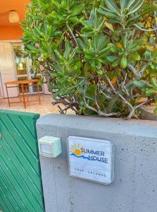 a sign for a summer house sitting on a wall at Summer House - Appartamento fronte mare in Marcelli +24 photos