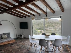 una sala da pranzo con tavolo e sedie bianchi di Nature&Soul - Sol a Vila do Bispo