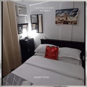1 dormitorio con 1 cama con almohada roja en Estien's cozy home, en Malagasang Primero