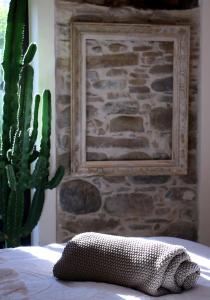 un oreiller assis sur un lit à côté d'un cactus dans l'établissement Talking Stones, à Dolceacqua