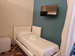 Habitación pequeña con cama y toallas. en B&B Porto Trani, en Trani