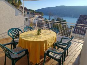 einen Tisch mit Weingläsern und Stühlen auf dem Balkon in der Unterkunft The Golden Hour in Herceg-Novi