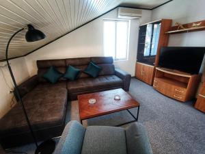 ein Wohnzimmer mit einem Sofa und einem TV in der Unterkunft The Golden Hour in Herceg-Novi