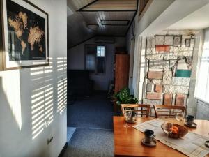 a dining room with a wooden table and a stone wall at The Golden Hour in Herceg-Novi +4 photos