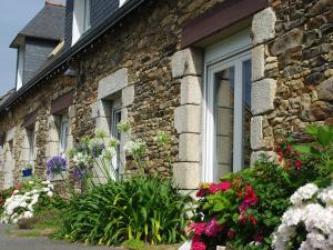 una casa de piedra con flores delante en Gîte ti Goudoul bébés enfants friendly en Moëlan-sur-Mer