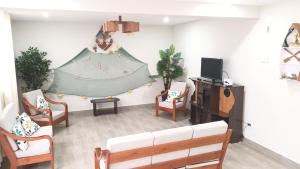 sala de estar con sofá y sillas en SAMANA WASI la punta, en Punta de Bombón