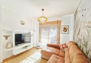 a living room with a couch and a television at Casa Bakara Zahara beach in Zahara de los Atunes