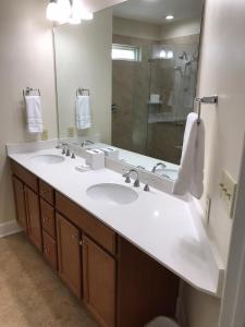a bathroom with two sinks and a large mirror at Ocean Palms Villa with Championship Golf Saturday to Saturday Rental in Hilton Head Island